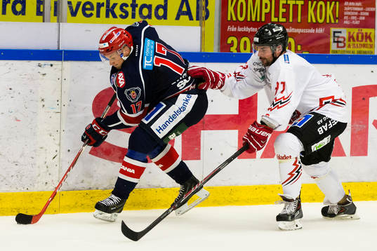 Södertäljes Jonas Engström med pucken jagad av Vita