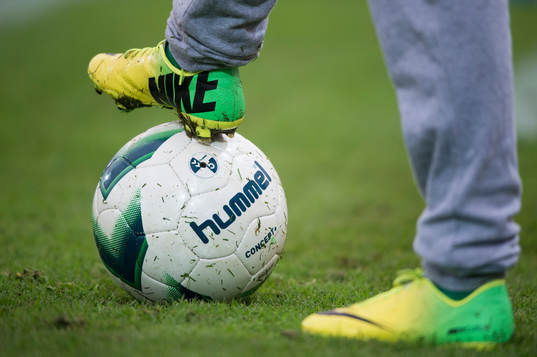 Fotbollsskor Nike och fotboll Hummel i matchen i