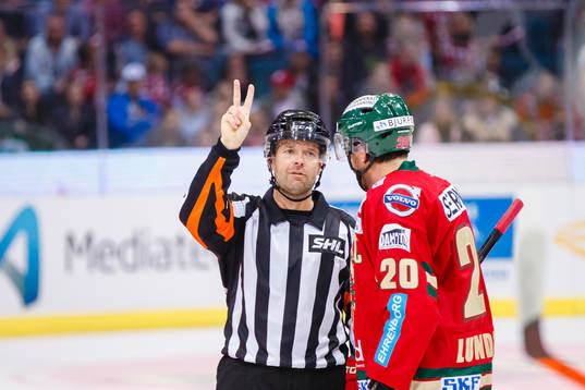 Domare Patrik Sjöberg visar två fingrar för Frölundas