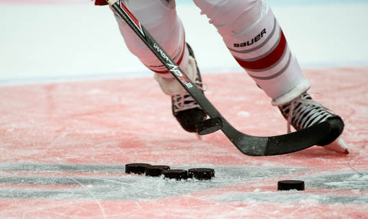 En spelare snor åt sig en puck ur puckhögen