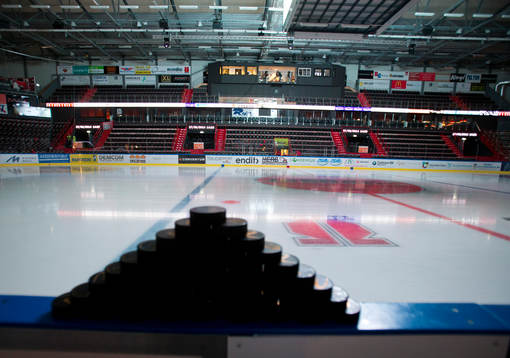 Hockeypuckar uppstaplade på sargen i Behrn Arena innan