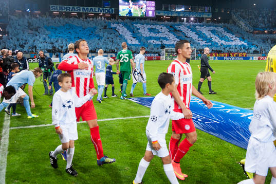Spelarna kommer in på planen innan fotbollsmatchen i