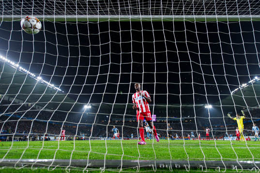 Olympiacos Eric Abidal ser bollen gå i mål för 1-0