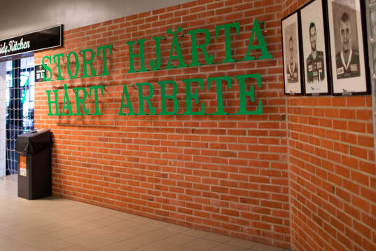 Interiörbild av korridor i Löfbergs Arena med texten