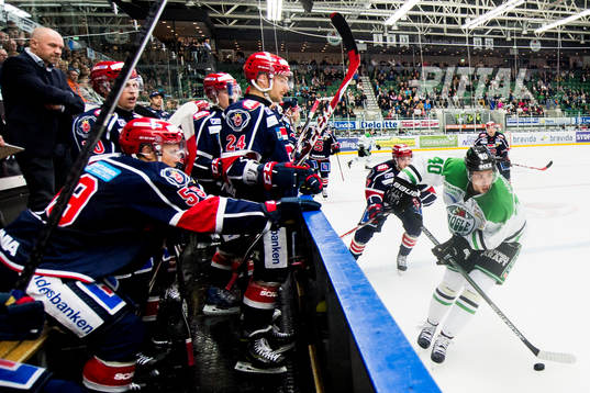 Rögles Jesper Jensen med pucken framför Södertäljes bås