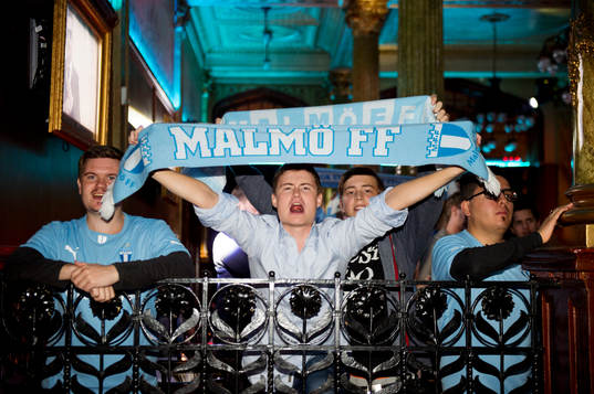 En supporter med halsduk jublar när Malmö FF firar sitt