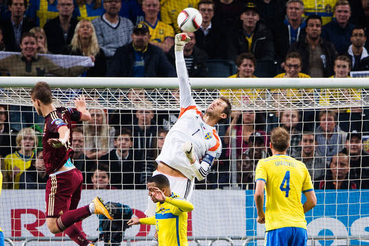 Sveriges målvakt Andreas Isaksson boxar bort en boll