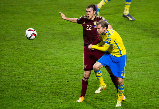 Rysslands Artem Dzyuba i kamp om bollen med Sveriges Mikael