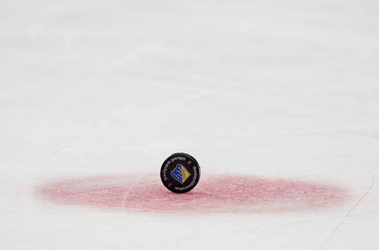 En puck med Södertäljes logotyp står på högkant på en