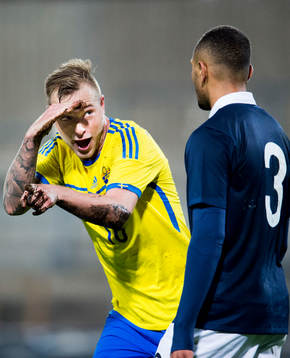 Sveriges John Guidetti jublar mot Frankrikes Layvin Kurzawa