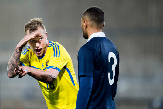 Sveriges John Guidetti jublar mot Frankrikes Layvin Kurzawa