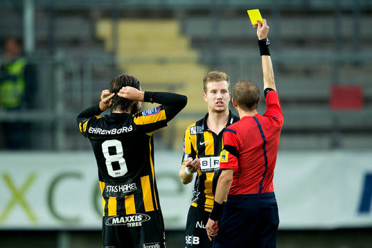Domare Johan Hamlin ger Häckens Simon Gustafson gult kort