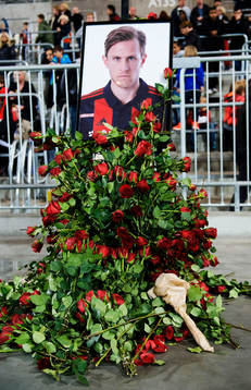 Blommor är utlagda vid ett porträtt av Pontus Segerström