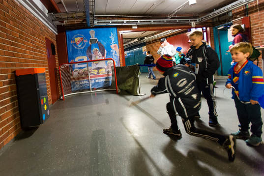 Ungdomar testskjuter med puck i publikutymmet innan