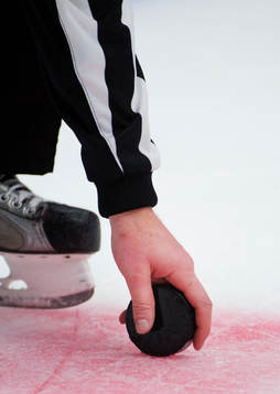 En domare tar upp en puck
