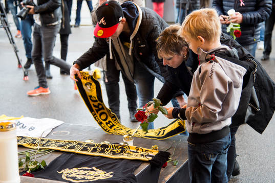 Supportrar lägger ner blommor och halsdukar