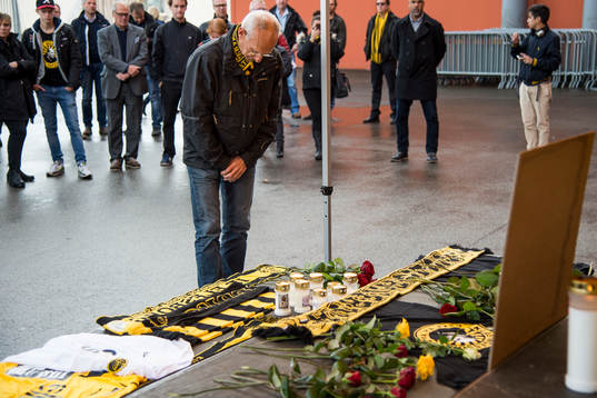 Supportrar lägger ner blommor och halsdukar