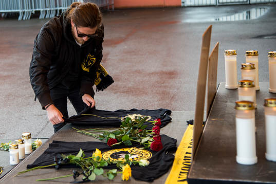 Supporter lägger ner en röd ros och tröja från