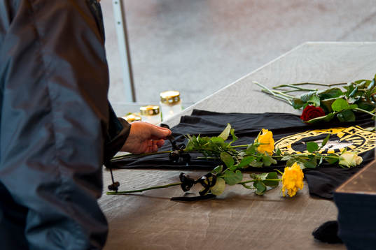 Sörjande supporter lägger ner en gul ros