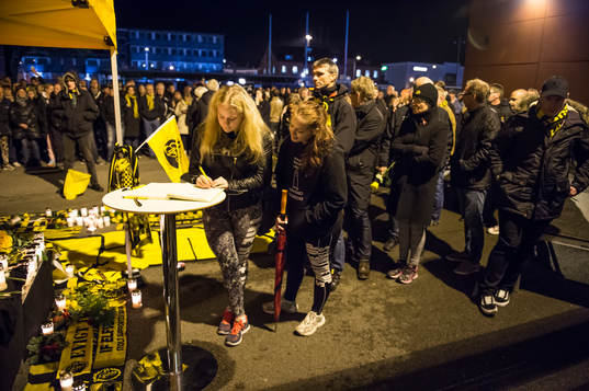 Sörjande skriver i kondoleansboken vid minnesplatsen