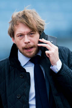 s kommunikationschef Peter Åhlander pratar i telefon