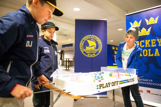 Ungdomar spelar bordshockeyspel i entrén till Tegera Arena