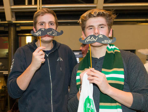 Mustaschprydda damer och herrar i movemberstil poserar på
