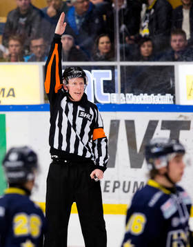 Domaren Mikael Holm håller upp armen för en avvaktande