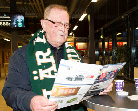 En supporter läser programbladet
