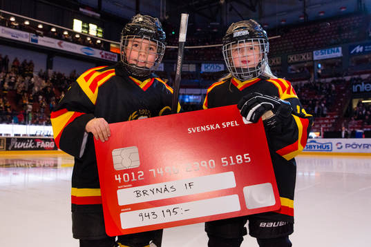 Två ungdomar från Brynäs håller upp en check från