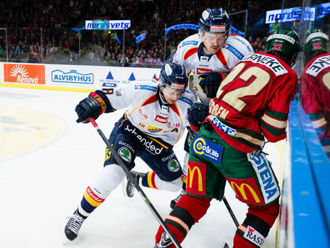 Frölundas Robin Figren i kamp om pucken vid sargen med