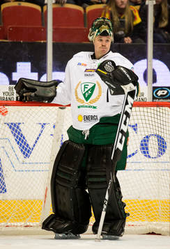 Färjestads målvakt Justin Pogge med mask i pannan deppar