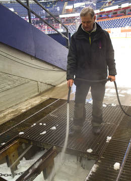 En vaktmästare spolar vatten på snön som samlats vid