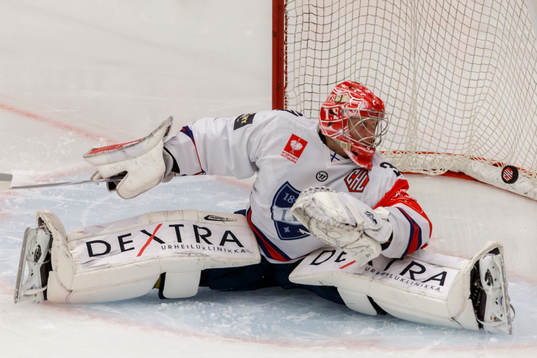 Helsingfors målvakt Ville Husso ser pucken gå i mål till