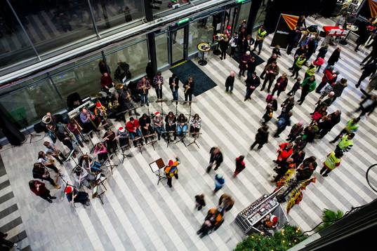 En orkester spelar julmusik i publikområdet av Gavlerinken