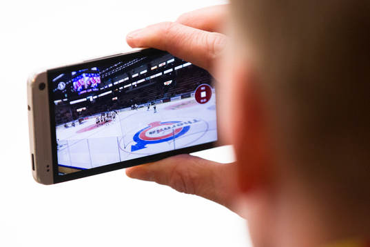 Supporter spelar in på sin mobiltelefon