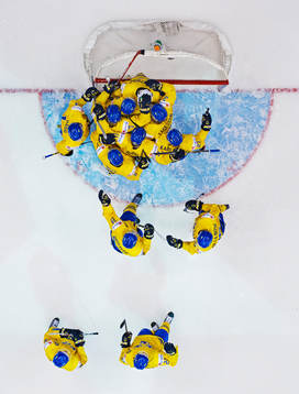 Sveriges spelare jublar efterr ishockeymatchen i JVM mellan