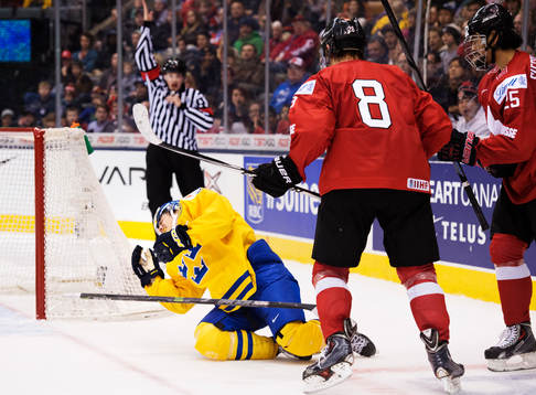 Sveriges Leon Bristedt blir tacklad av Schweiz Timo Meier