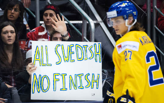 En man håller upp en skylt med texten "All Swedish No