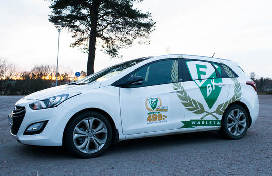 En bil med påklistrade färjestadsdekaler står parkerad
