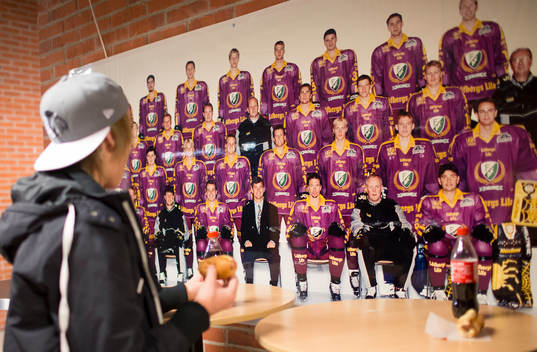 En supporter studerar ett äldre lagfoto på Färjestad