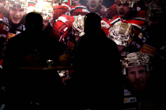 Två besökare sitter vid ett bord innan ishockeymatchen i
