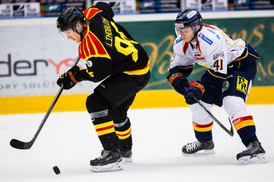 Brynäs Oskar Lindblom med pucken jagas av Djurgårdens