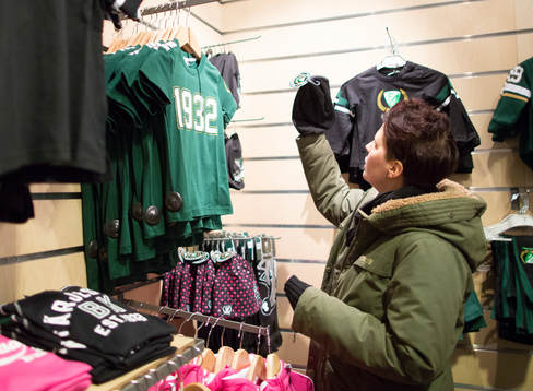 En kund tittar på tröjor i Färjestadsshopen