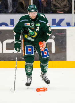 Färjestads Rickard Wallin plockar upp flaskor från isen