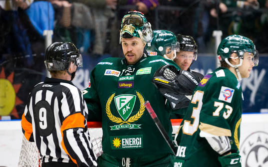 Färjestads Rickard Wallin plockar upp flaskor från isen