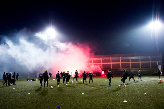 Malmö FFs spelare tränar och publiken bränner bengaler
