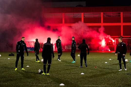 Malmö FFs spelare tränar och publiken bränner bengaler
