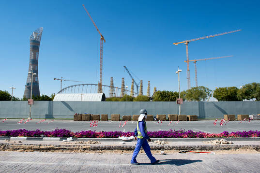 En arbetare passerar utanför Khalifa International Stadium