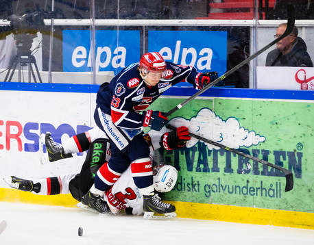 Malmö Redhawks Nils Andersson tacklar in i sargen av